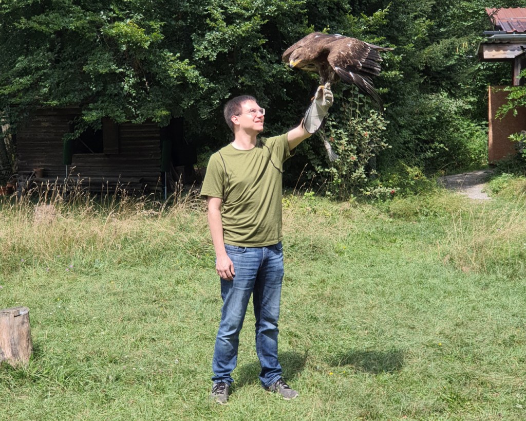 Sebastian mit dem Steppenadler auf der Hand, der gerade gelandet ist (© Cornelia Hebrank, 2024)