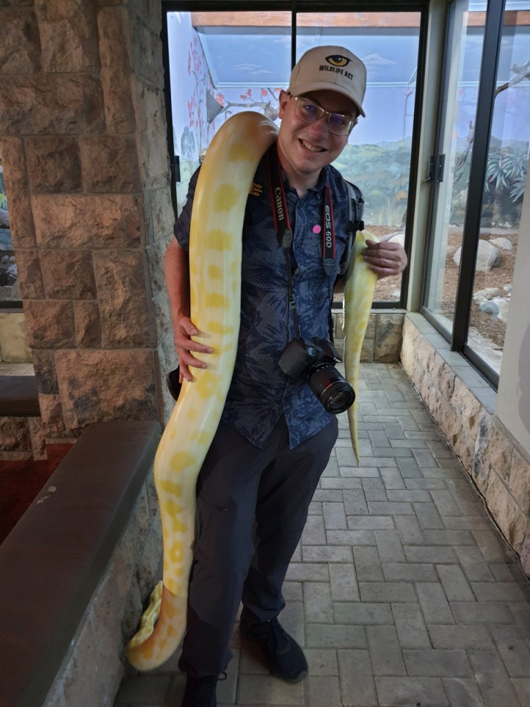 Sebastian mit der großen gelb-weißen Schlange über der Schulter (© Cornelia Hebrank, 2024)